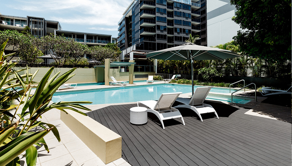 A swimming pool with lounge chairs and composite decking.
