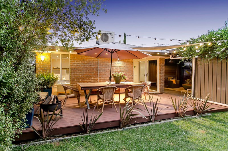 A backyard with a composite decking outdoor table and chairs.